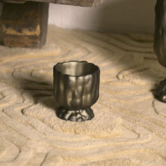 Decorative metal cup on a textured stone surface