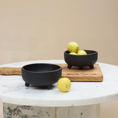 2 Pluto Bowls placed on a marble table, made of ceramic in black color