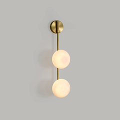 side look of Link Wall Sconce with brass finish and glass aesthetic.