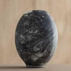 Decorative Bella Black Vase made of glass with marble-patterned design on a beige background