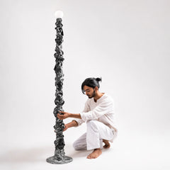 Person styling the Cosmos Totem Floor lamp by Keph Design Studio
in a room setting