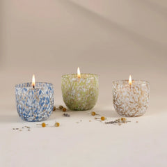 Monet's Garden Votive Candle Set Of 3, lit blue, green and amber speckled glass votives in a row with Stunning Oud fragrance