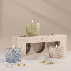 Monet's Garden | Votive Candle | Stunning Oud | Set Of 3, three lit speckled glass votives around gift box with dried flowers