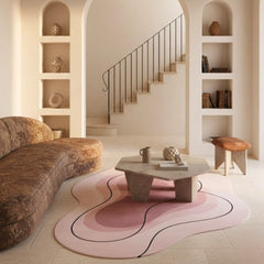 Modern living room with a pink and black rug, brown sofa, and decorative items.