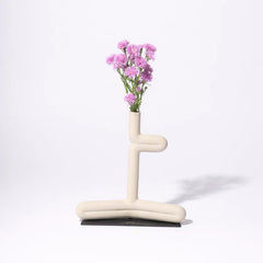 Modern ceramic vase with pink flowers on a white background