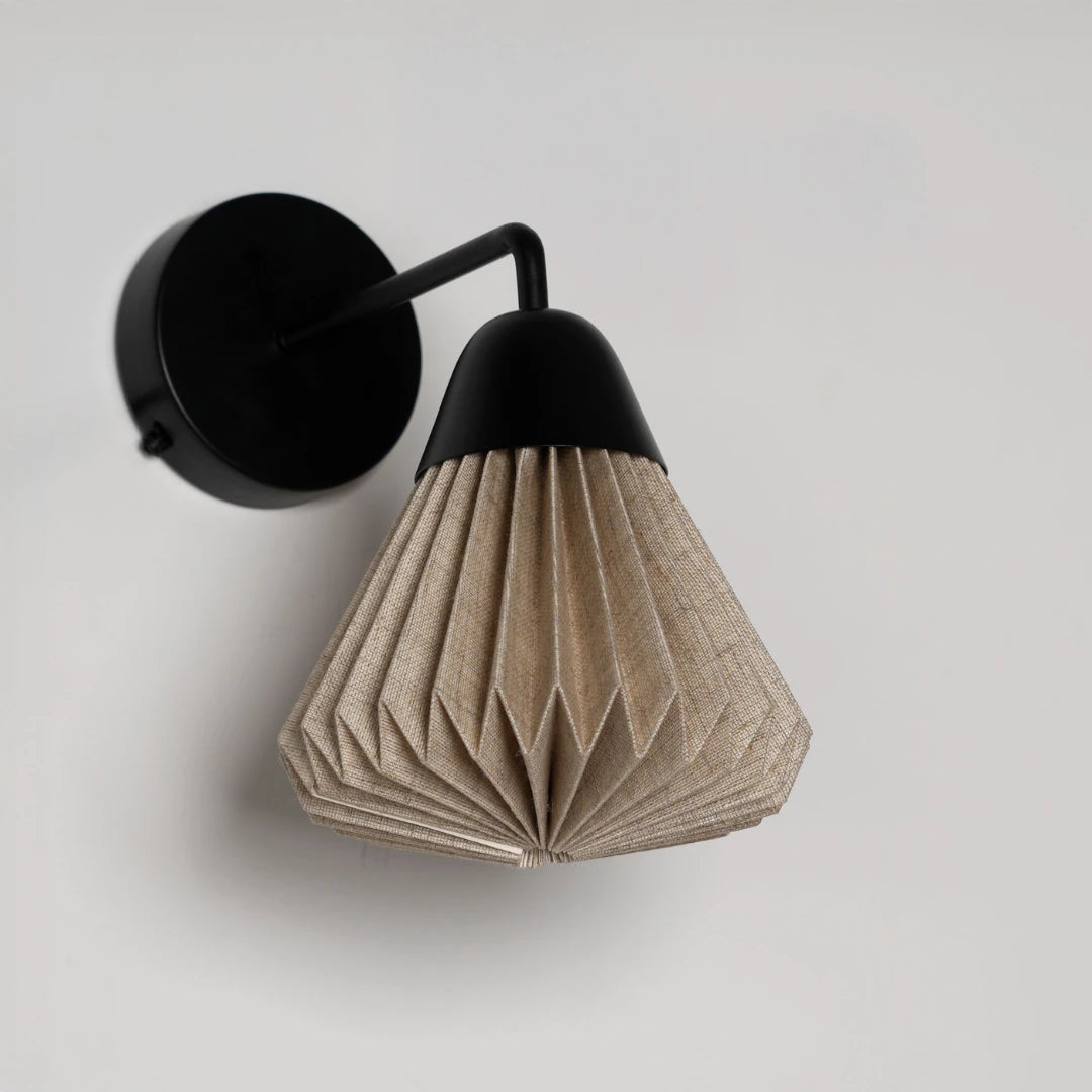 Linen Downlighter Wall Sconce with black fixture and beige pleated shade on a light gray background