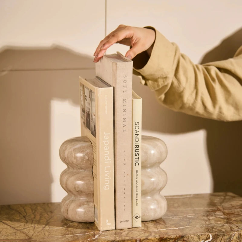 Ripple Bookend - Holding Books on Marble Shelf, Hand Adjusting Book