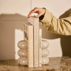 Ripple Bookend - Holding Books on Marble Shelf, Hand Adjusting Book
