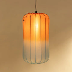 Pendant light with orange gradient glass shade on a beige background