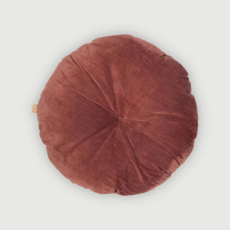 Round brown cushion on a light gray background