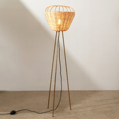 Tripod rattan floor lamp with a warm ambient lighting.