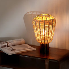 Cane Meiji Table Lamp on a wooden surface with an open book and rolled-up newspaper.