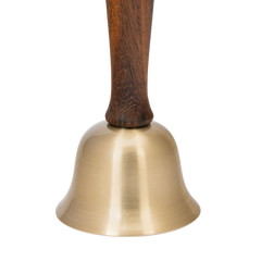 Decorative brass bell with wooden handle on a white background