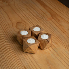 Top view of four marine plywood candle holders with candles on a wooden surface