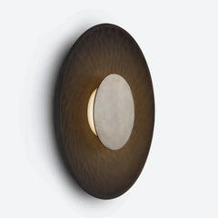 Stoneware disc wall lamp, round wall light fixture with a dark brown and white design on a light gray background