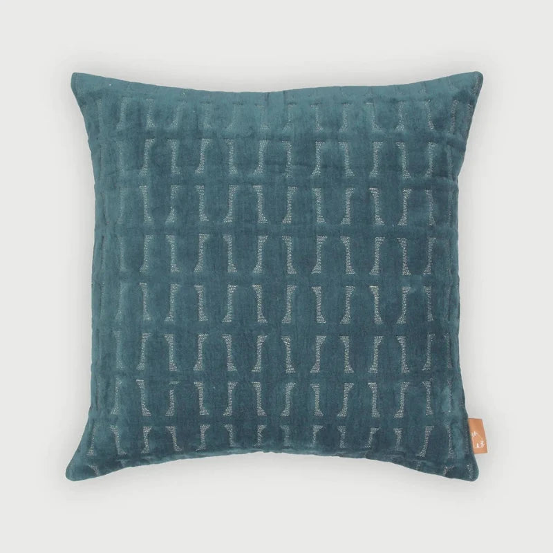 A square teal blue-green throw pillow with a textured geometric pattern, shown against a light gray background.