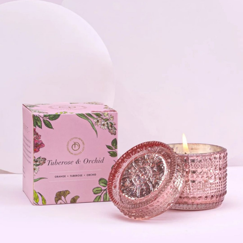 Tuberose & Orchid Fragrance Trinket glass candle jar with lid and its matching floral-patterned box, labeled 'Tuberose & Orchid' on a clean white background.  