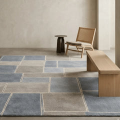 Modern interior with a patterned rug, wooden chair, and bench.