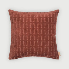 A square throw pillow in a textured rust-brown velvet fabric with a raised geometric pattern, shown against a light gray background.