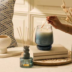 Cosmic Set - Lid Jar Candle (M) & Diffuser - Dusk - Balmy Bergamot - Set of 2, hand lighting the candle beside diffuser