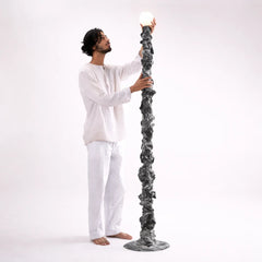 Man holding the Cosmos Totem Floor lamp to show scale, height & textured sculpture 