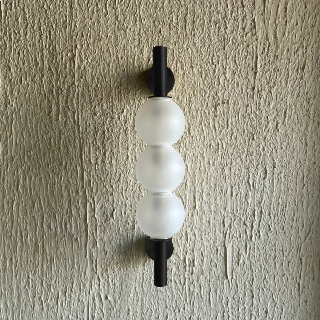 Glass orb wall sconce home lighting modern decor on textured wall