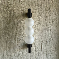 Glass orb wall sconce home lighting modern decor on textured wall