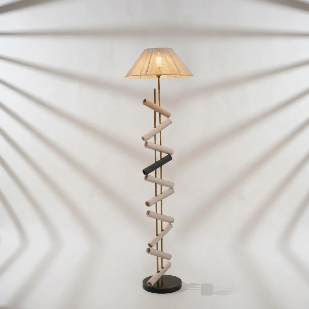 Spiral design floor lamp with a beige shade on a white background