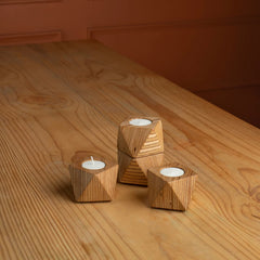 Chamfer Tealights: three wooden candle holders with candles on a wooden surface 
