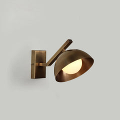 Molt Wall Sconce made of Brass Dome shade with adjustable arm on a gray background