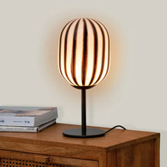 Designer Bullseye Table Lamp, casting warm light placed on a wooden table