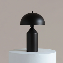 Black Cone Pagen Table Lamp on a white pedestal against a beige background