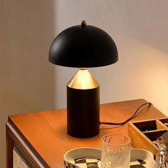 Black Cone Pagen Table Lamp on a wooden surface with a warm glow