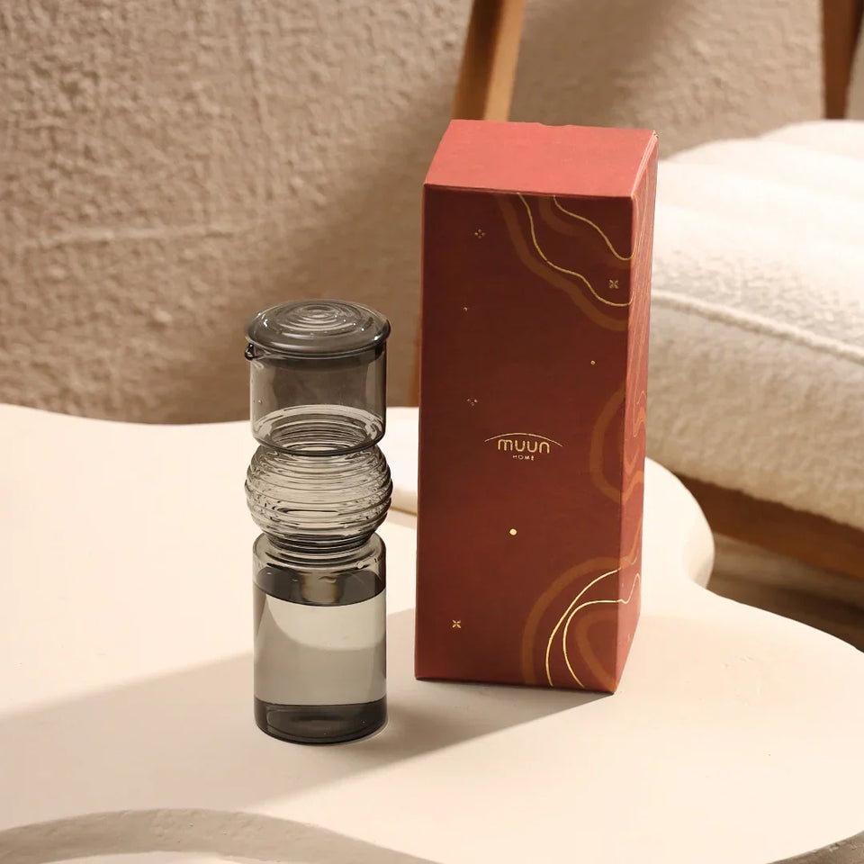 Coil Glass Carafe with a red box labeled 'muun home' on a light surface.