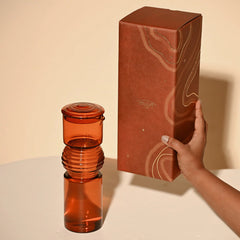 Coil Glass Carafe in amber color next to the box with branding "muun home"