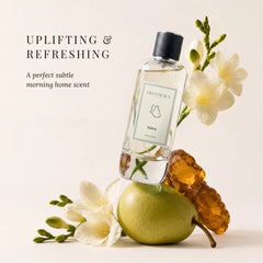 Eden - Uplifting & Refreshing Perfume Room Spray - Tilted Glass Bottle on Green Pear with White Freesia & Amber Resin, Angled View