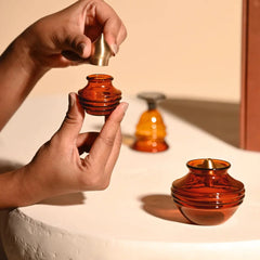 Kalash Oil Lamp + Small Ringing Bell + Mini Kalash, hands fitting gold-tone cap on mini kalash
