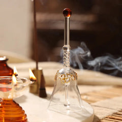 Kalash Oil Lamp + Ringing Bell, clear glass bell with gold Om detail near lit diyas and incense smoke