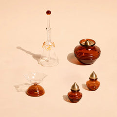 Muun Diya Gift Box pieces in amber borosilicate glass and brass, short diya, bell and kalash, top view