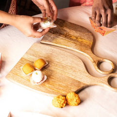 Wooden Yin-Yang Platter Set of Two, hands arranging Indian sweets on mango wood platters