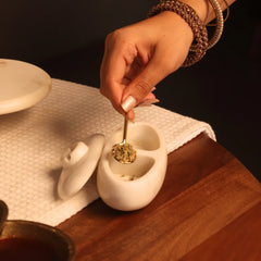Twin Marble Server, hand scooping with gold spoon from open compartment, lid set aside, side view