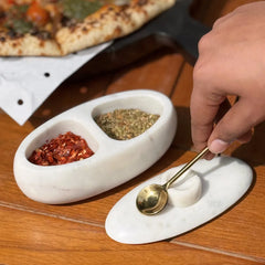 Twin Marble Server with chilli flakes and dried herbs, lid and gold spoon beside, top angle