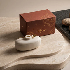 Twin Marble Server closed with gold spoon on lid, white marble, on stone board beside gift box
