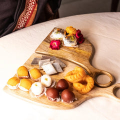 Wooden Yin-Yang Platter Set of Two with assorted Indian sweets and roses, mango wood, angled view
