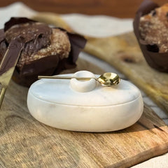 Twin Marble Server closed with gold spoon on lid, white marble, on wooden board with muffins