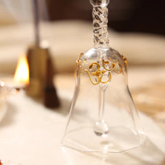 Glass Ringing Bell, close-up of clear glass bell with gold Om detail and twisted stem