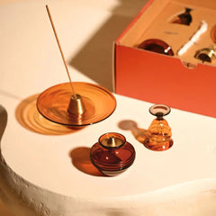 Kalash Oil Lamp + Incense Holder + Small Bell, amber glass set on white plinth with open gift box behind