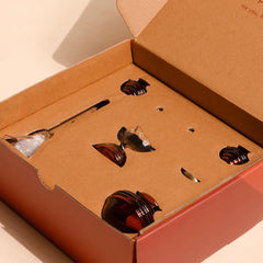 Muun Diya Gift Box open, pieces nested in kraft insert inside orange box, front top view