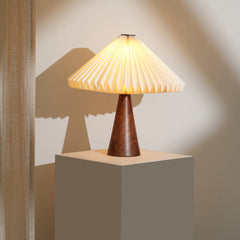 Ballet Table Lamp with Wooden Base & pleated design, casting a soft shadow on a neutral background