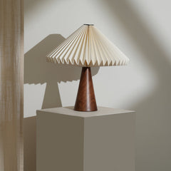 Ballet Table Lamp with pleated beige shade and wooden base on a neutral background